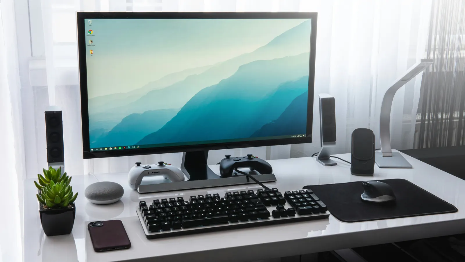 Tidy PC desk with monitor, keyboard and controllers for managing multiple Minecraft accounts