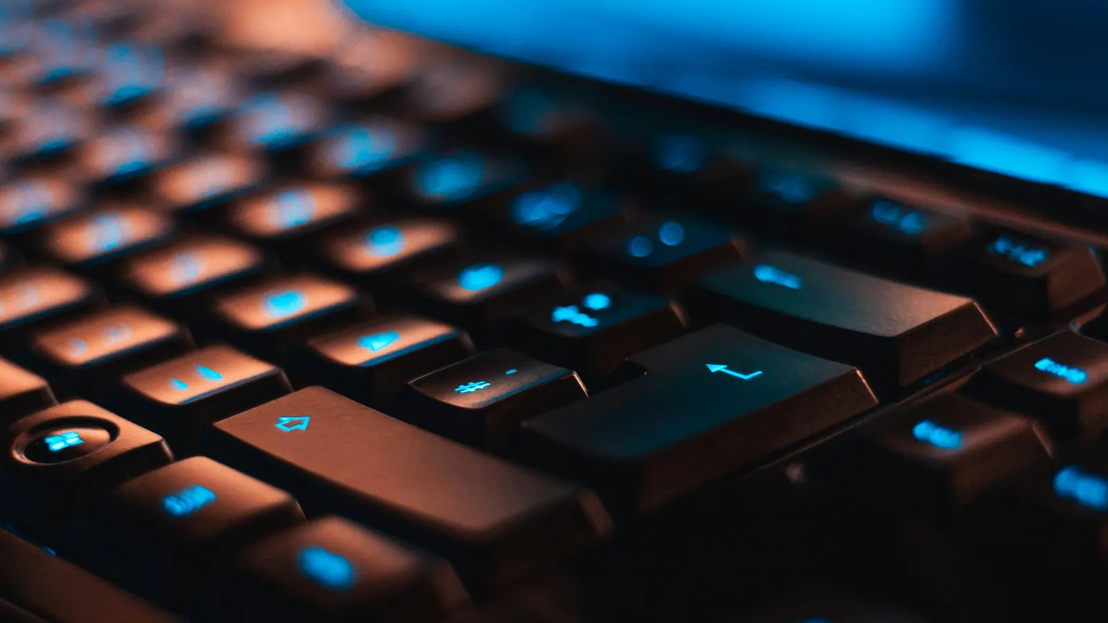 Backlit gaming keyboard in blue light, illustrating Hypixel unbanned alts for Minecraft